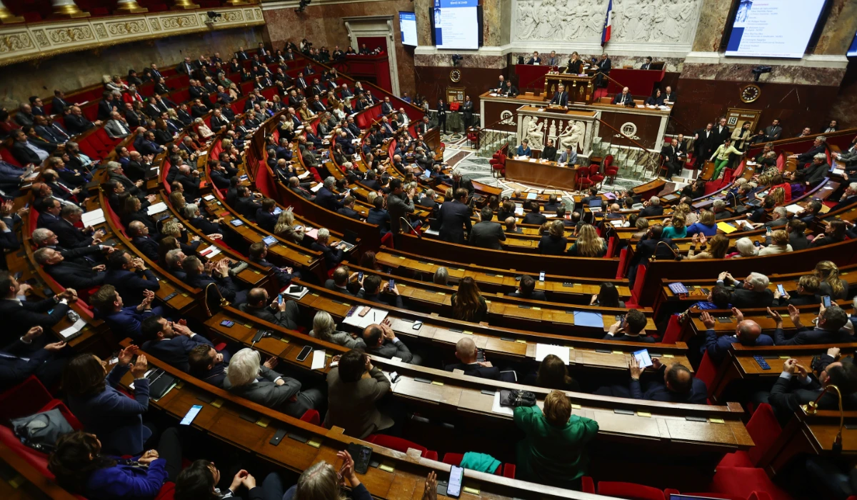 French Interior Minister Gerald Darmanin (C-rear) speaks during a debate on the new immigration bill at the National Assembly in Paris, France, 19 December 2023. (EPA)