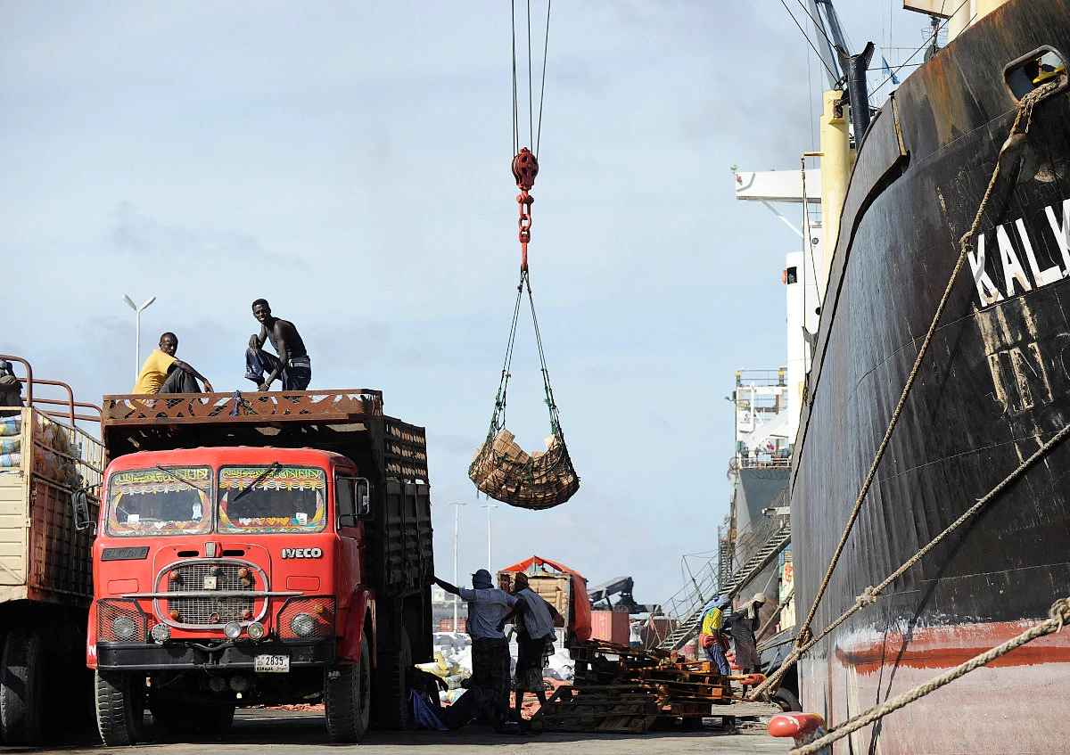 In this picture taken on April 24, 2013, Somalian porters offload goods in the sea port of Mogadishu from a foreign vessel hijacked for ransom by pirates. (AFP/File)
