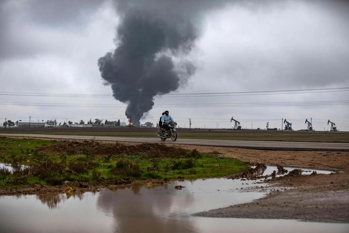 Thick smoke billows from a raging fire at a storage tank of the al-Awda oil field facility near al-Qahtaniyah in northeastern Syria. (AFP)