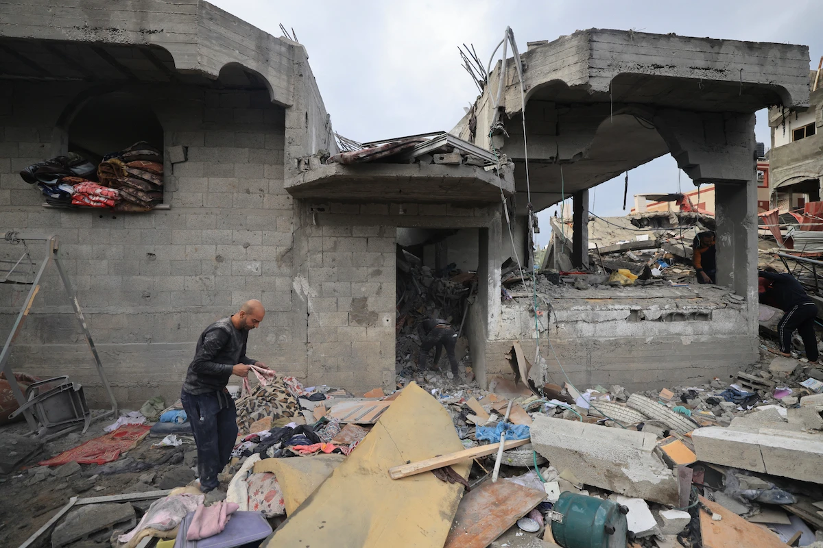 Palestinians inspect the damage at the Al-Maghazi refugee camp after an overnight Israeli strike on December 25, 2023. (AFP)
