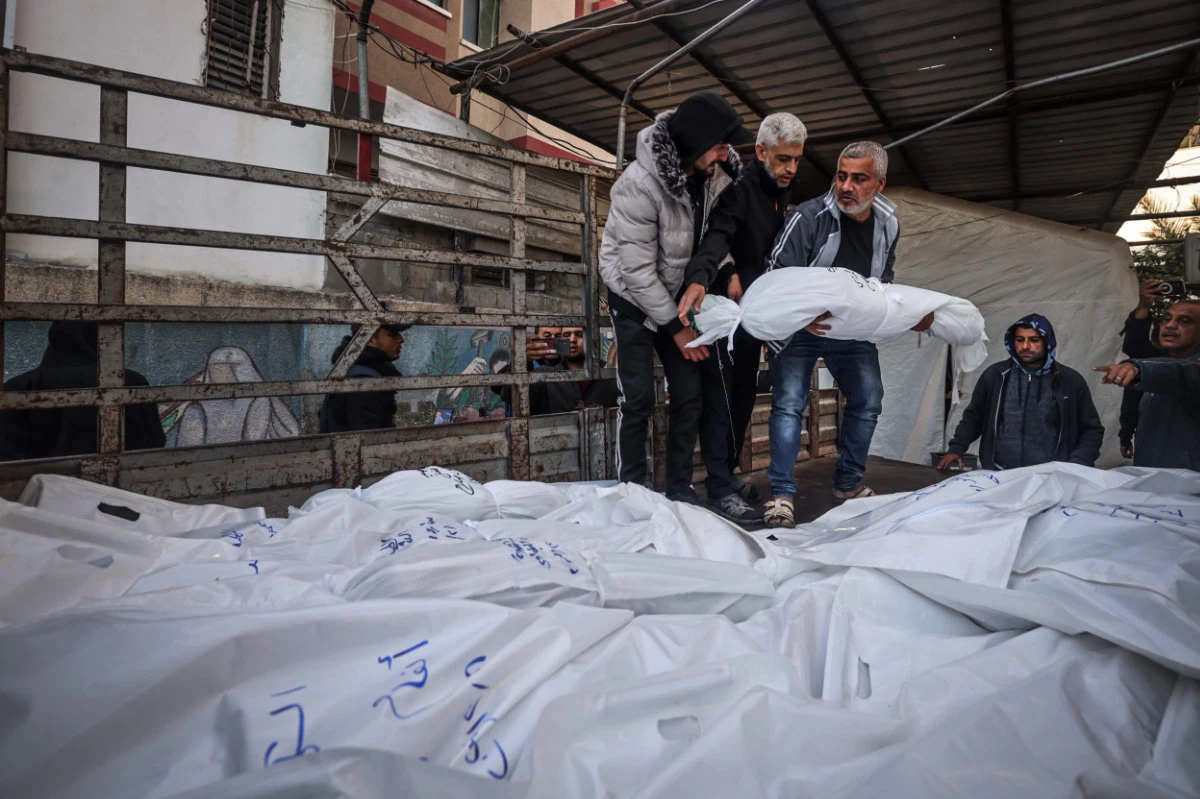 The shrouded bodies of people killed in Rafah during Israeli bombardment are placed on a truck for burial outside Al-Najar hospital on December 29, 2023. (AFP)