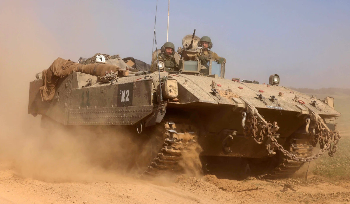 This photograph taken near the border with the Gaza Strip shows Israeli soldiers on an armoured personnel carrier (APC) rolling back from the Gaza Strip, on December 31, 2023 amid continuing battles between Israel and the militant group Hamas. (AFP)