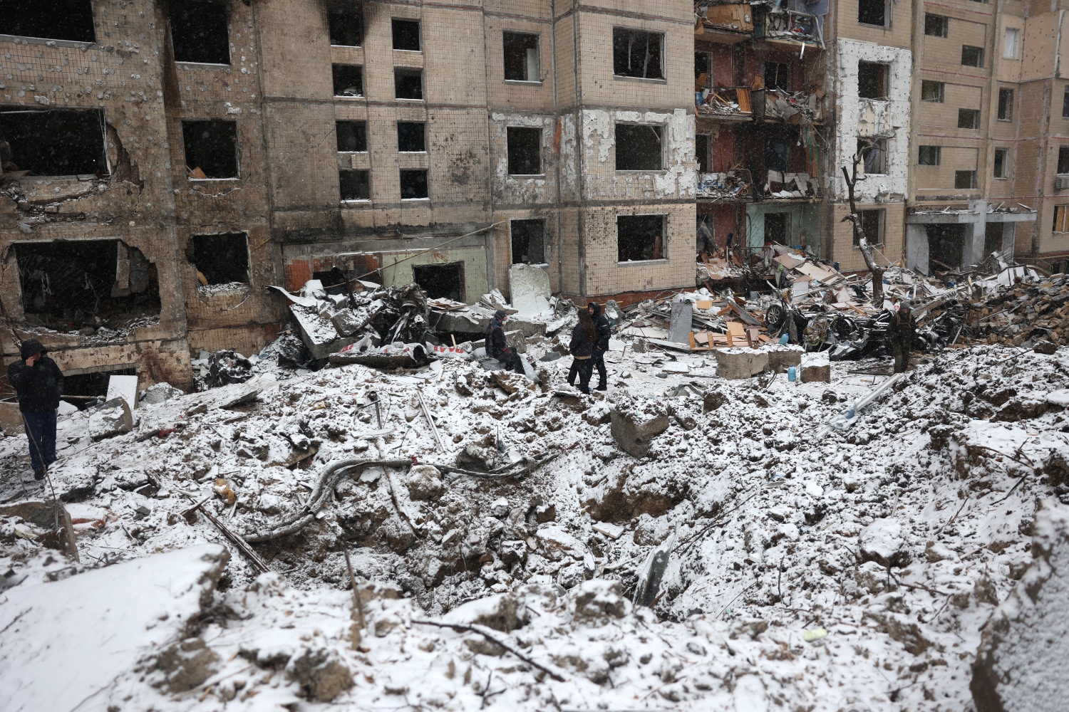 Police officers and residents inspect damage outside a destroyed building following a Russian missile attack in central Kyiv-AFP