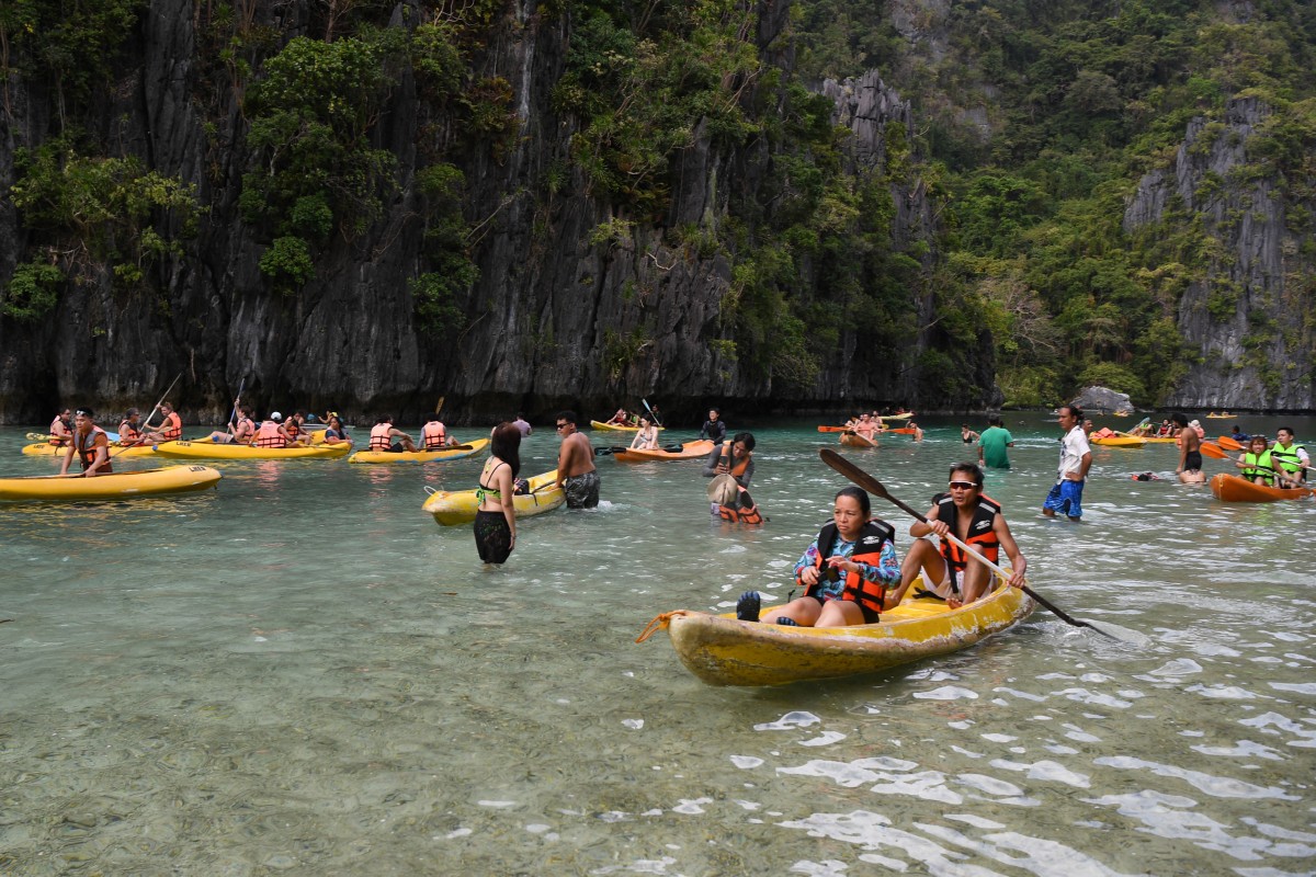 This photo taken on Dec. 12, 2023 shows tourists paddling their kayaks while others take photos inside the Big Lagoon in El Nido town, Palawan province, the Philippines. (AFP)
