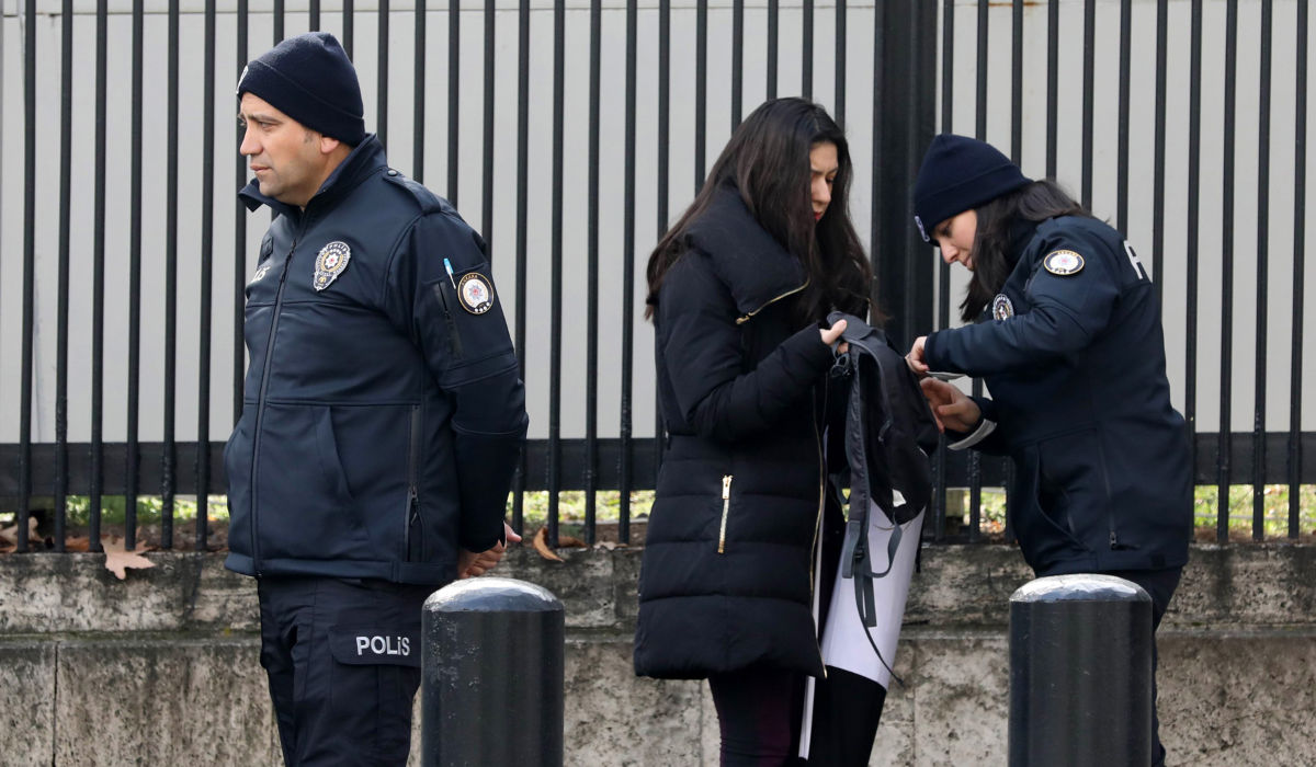 Policemen search a woman outside the United States embassy in Ankara. (AFP file photo)