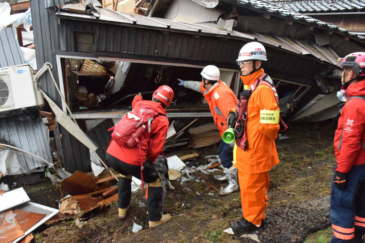 Firefighters search a collapsed house for earthquake survivors in the city of Suzu, Ishikawa prefecture on January 3, 2024. (JIJI PRESS / AFP)