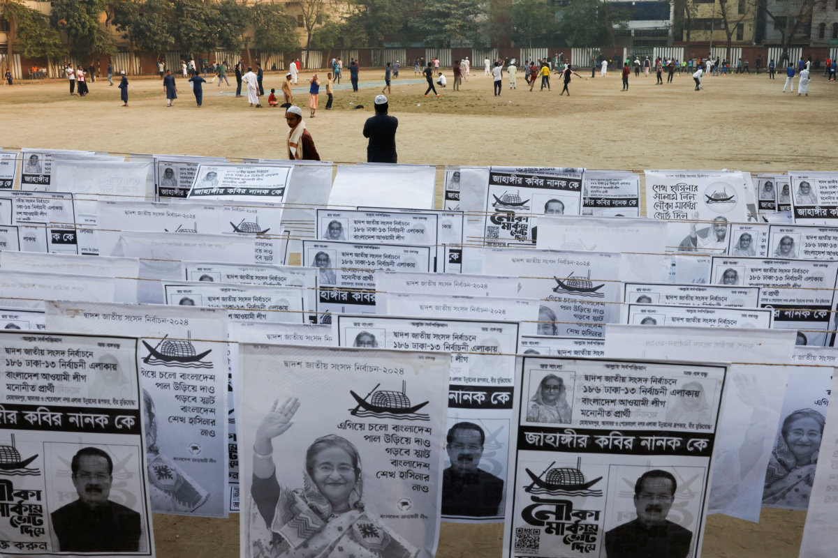 People play as election campaign posters of a candidate from Bangladesh's Awami League, with the picture of Prime Minister Sheikh Hasina hang in a park in Dhaka on January 3, 2024' ahead of the general election of Bangladesh. (Reuters)