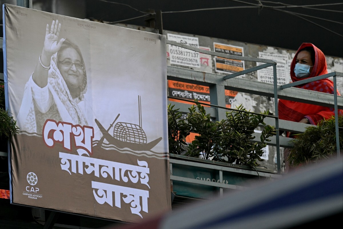 A pedestrian walks past an election poster of Awami League featuring its leader and Bangladesh’s Prime Minister Sheikh Hasina in Dhaka on Jan. 4, 2024, ahead of the upcoming general elections. (AFP)