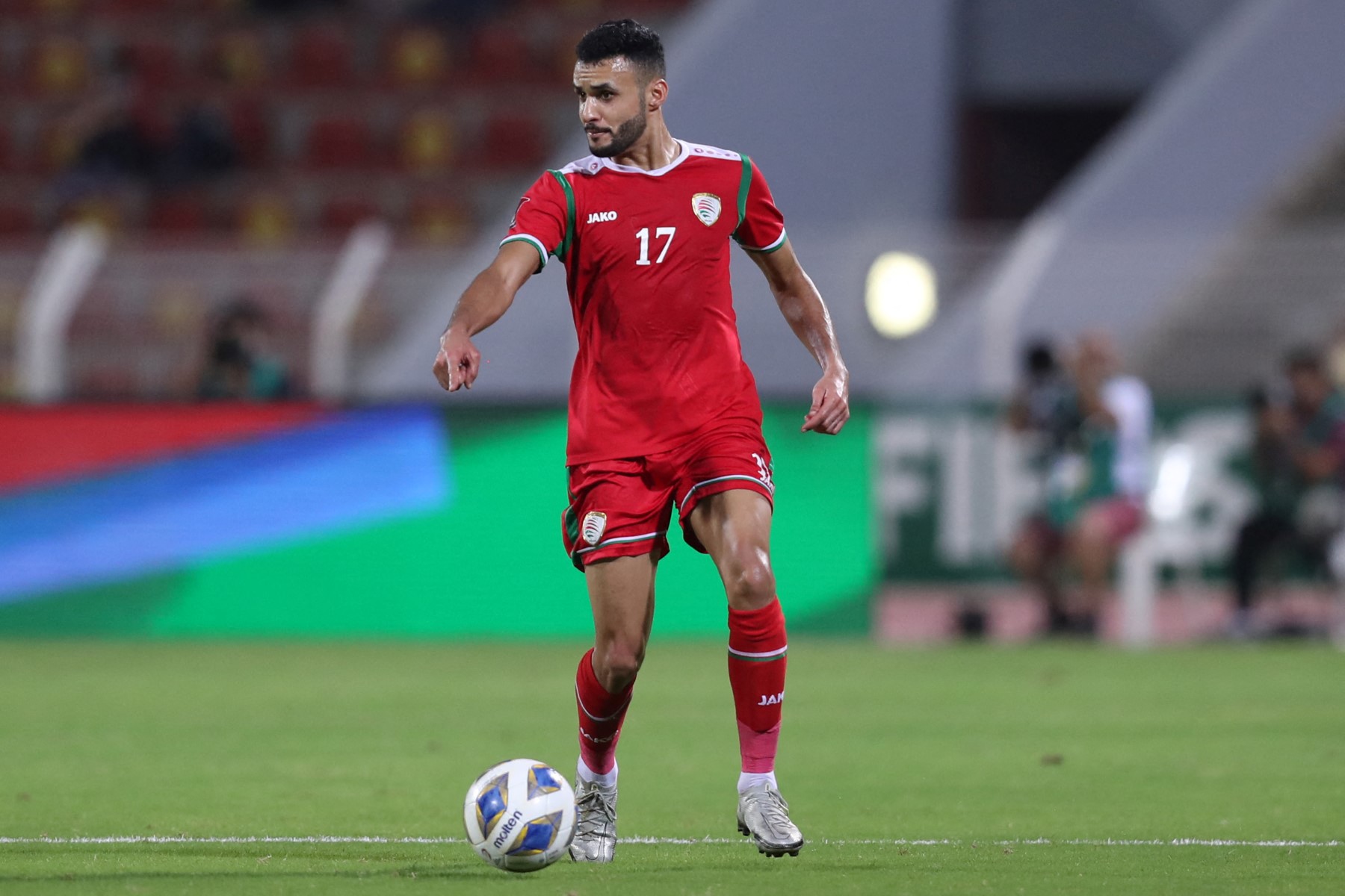 Oman's defender Ali al-Busaidi runs with the ball during the 2022 Qatar World Cup Asian Qualifiers football match between Oman and Japan (AFP)