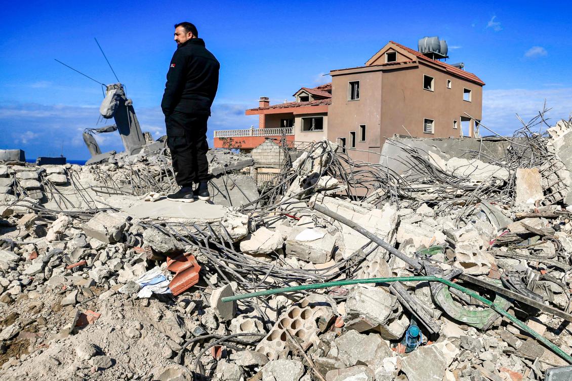 A man stands amidst the rubble of destroyed buildings following strikes on the the town of Naqura in southern Lebanon close to the border with northern Israel on January 4, 2024. (AFP)