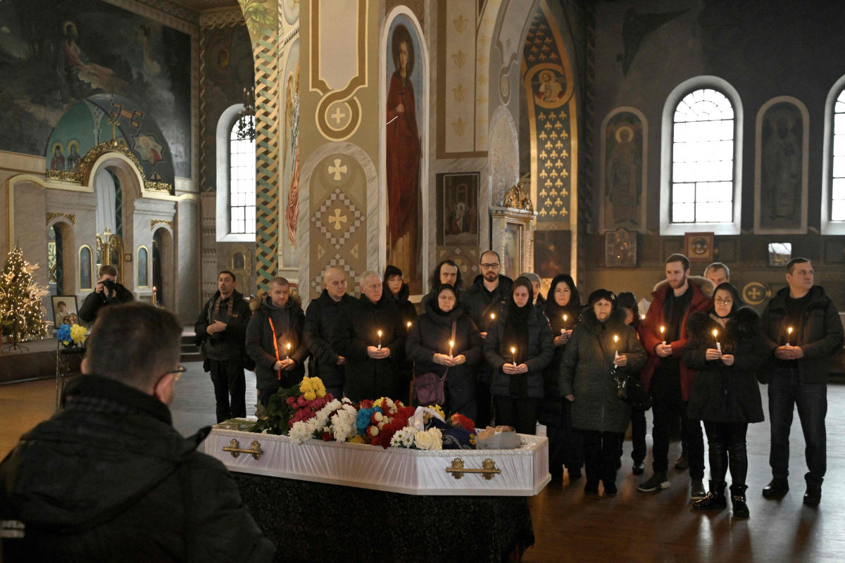 Relatives and friends mourn at a church in Kyiv on January 5, 2024, during the funeral service of Lyudmyla Shevtsova, an 84-year-old scientist who was killed at her apartment on January 2, 2024, following a Russian missile attack. (AFP)