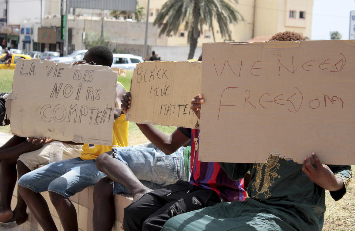 Migrants hold placards reading "Black Lives Matter", left, in French, during a gathering in Sfax, Tunisia's eastern coast, on July 7, 2023. (AP)
