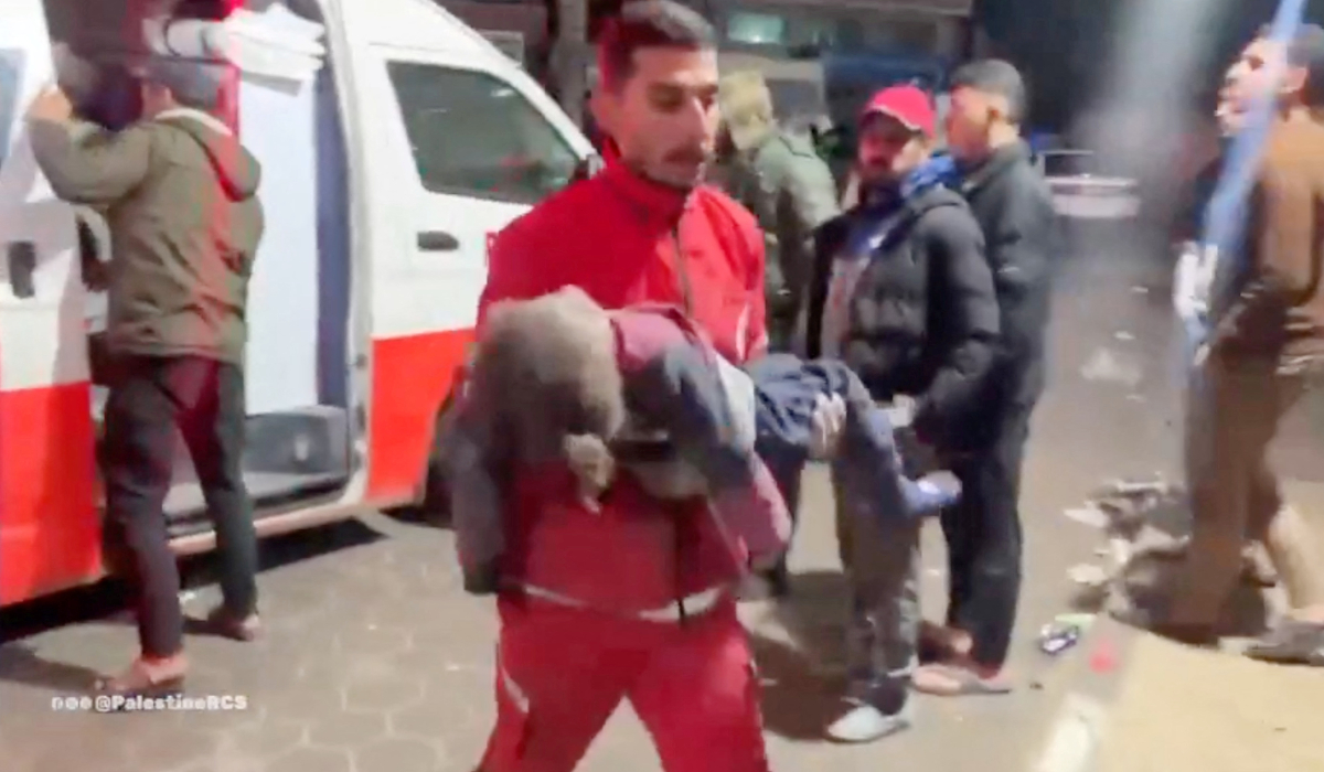 A member of Palestine Red Crescent ambulance team carries a child casualty from an ambulance to Shuhada al-Aqsa hospital, amid the ongoing conflict between Israel and the Palestinian Islamist group Hamas, in Deir Al-Balah, in the central Gaza Strip, in this still image obtained from video released January 8, 2024. (REUTERS)