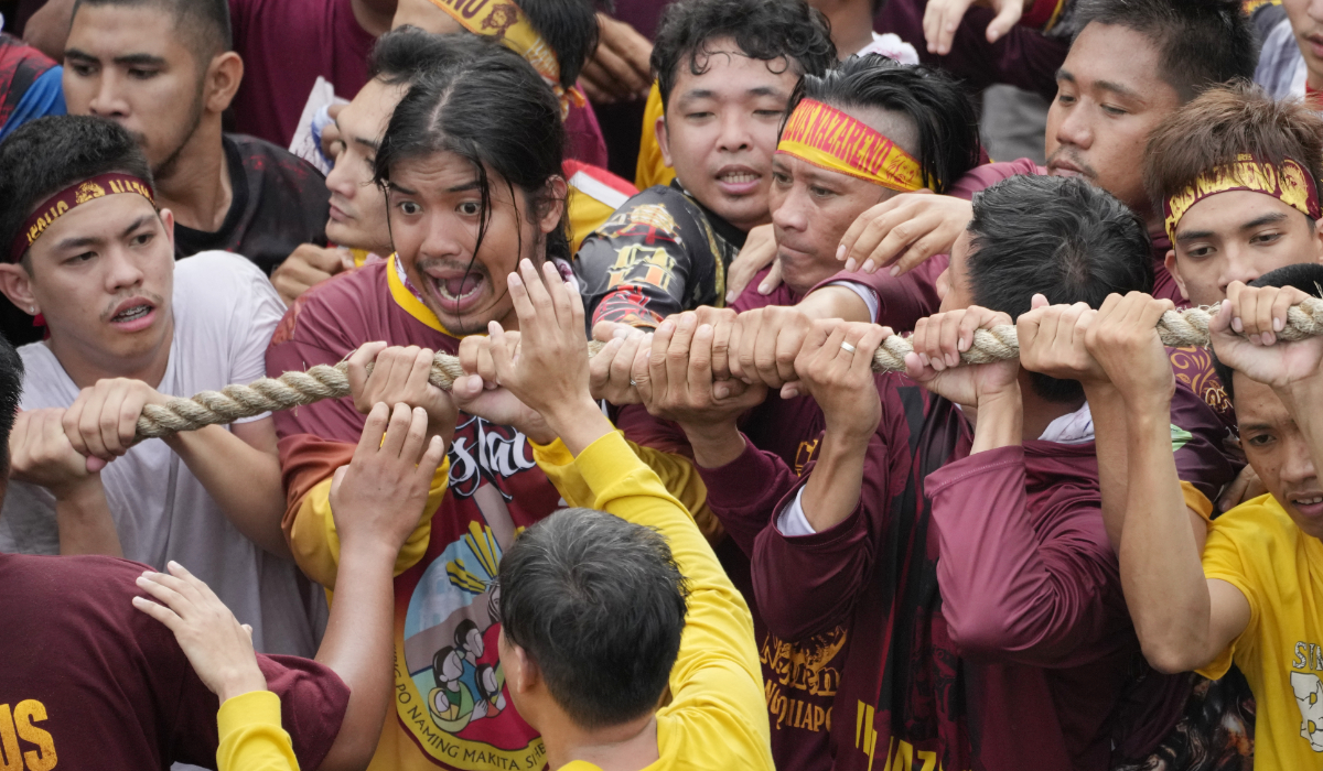 Devotees grab the rope as they pull the glass-covered cart carrying Black Nazarene during its annual procession which was resumed after a three-year suspension due to the coronavirus pandemic on Tuesday, Jan. 9, 2024 in Manila, Philippines. (AP)