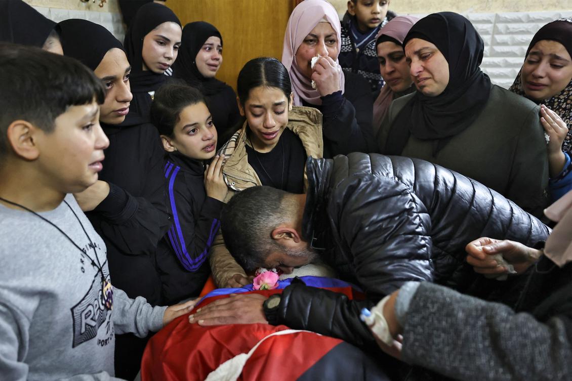 Relatives mourn over the body of a man killed during an overnight Israeli raid on the Tulkarem refugee camp in the occupied West Bank on Jan. 9, 2024. (AFP)