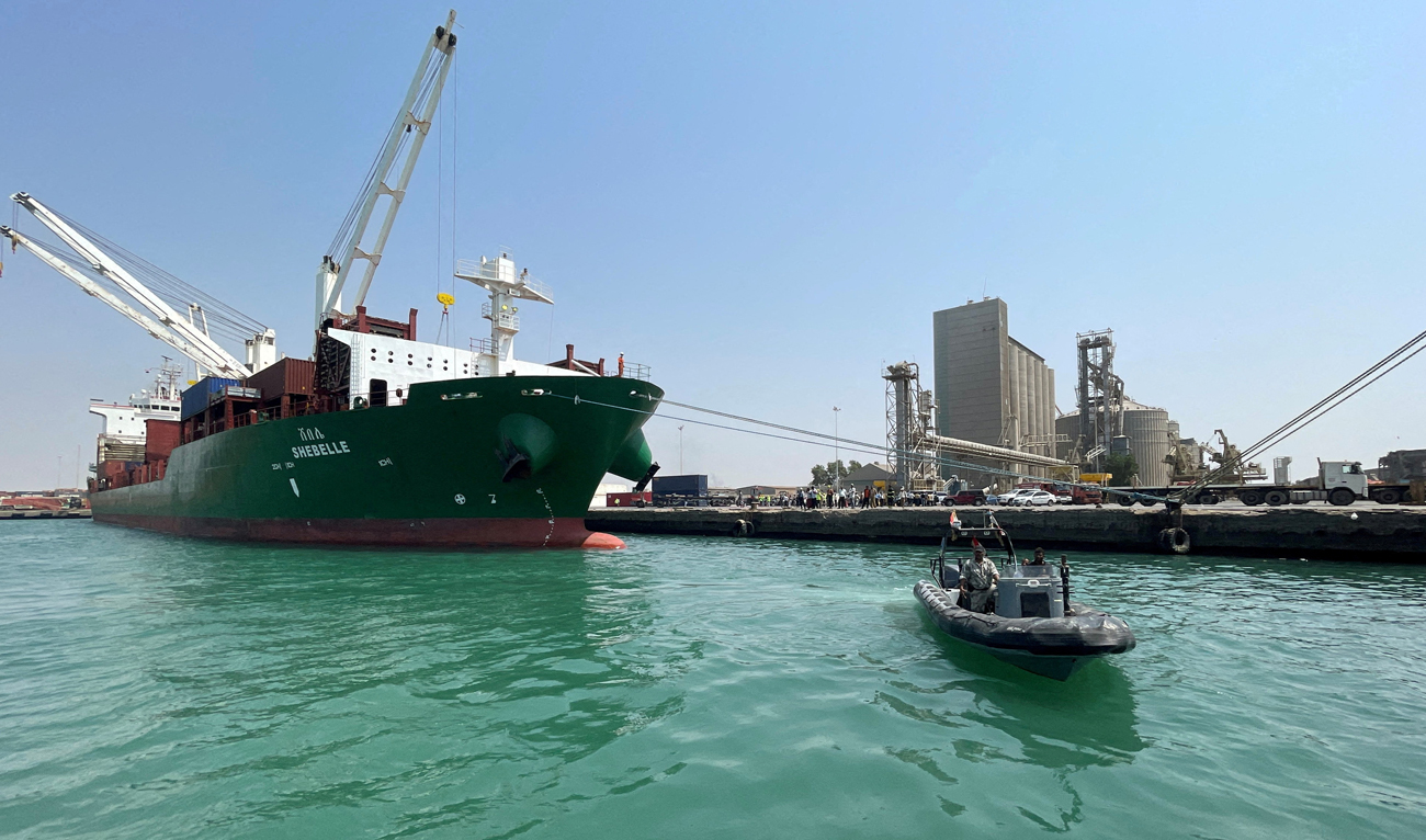 A coastguard boat sails past a commercial container ship docked at the Houthi-held Red Sea port of Hodeidah, as a container ship carrying general commercial goods docked at the port for the first time since at least 2016, in Hodeidah, Yemen February 25, 2023. (REUTERS/File)