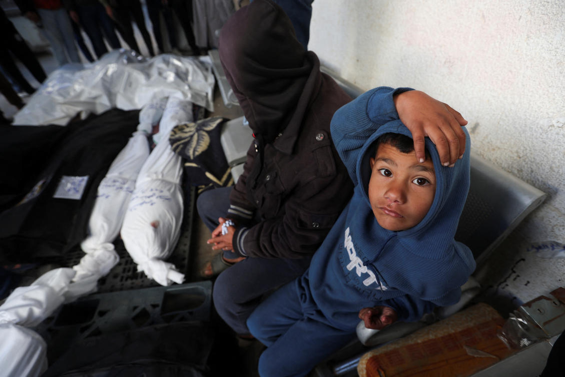 People sit near the bodies of Palestinians killed in an Israeli strike, amid the ongoing conflict between Israel and the Palestinian Islamist group Hamas, at Abu Yousef al-Najjar hospital, in Rafah in the southern Gaza Strip, January 13, 2024. (Reuters)