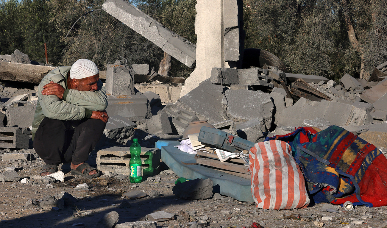 A man sits amid the rubble following Israeli bombardment in Rafah in the southern Gaza Strip on January 13, 2024, amid ongoing battles between Israel and Palestinian group Hamas.