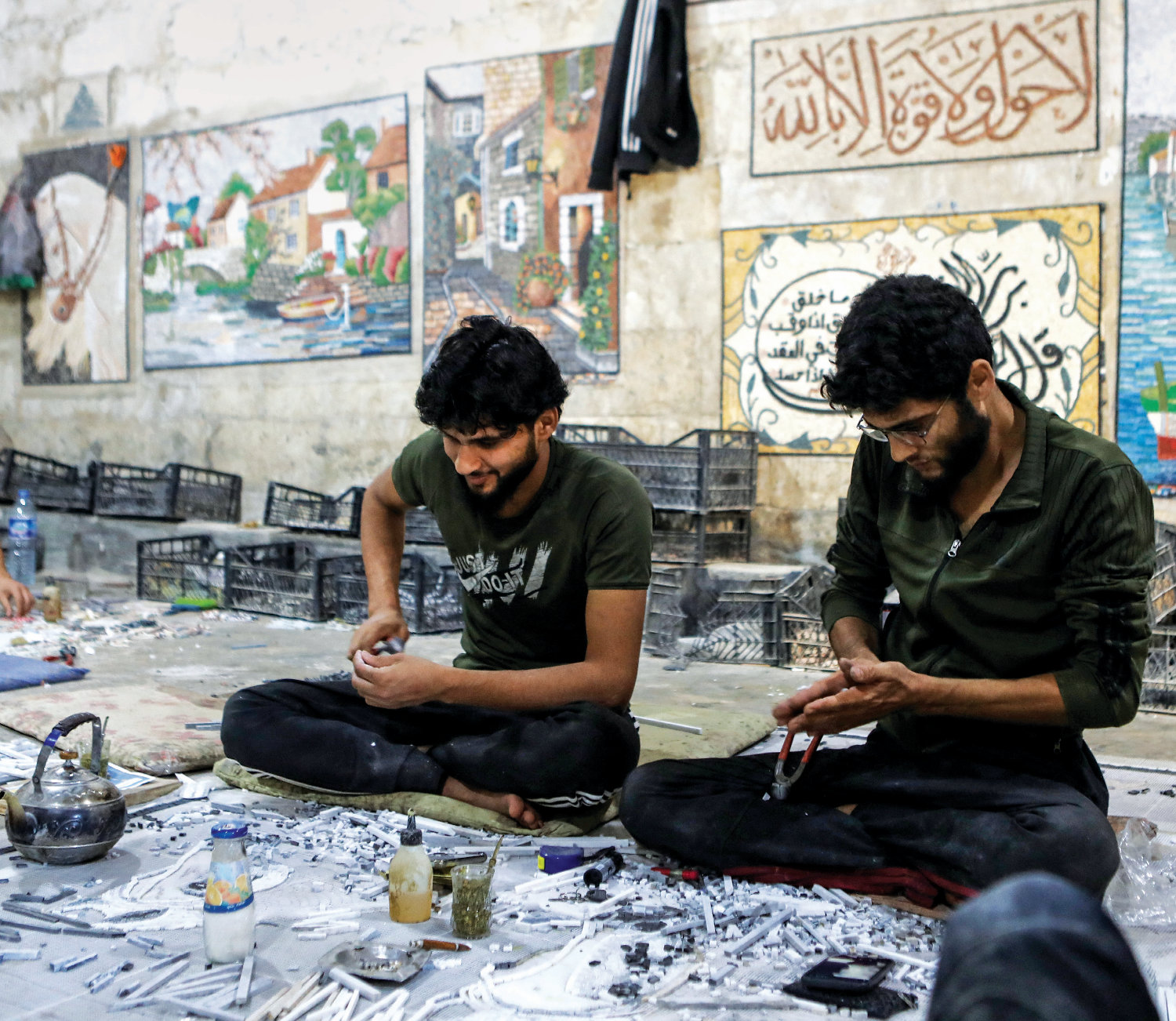 Employees of a mosaic workshop work on panels, main, in a town in the war-ravaged Syrian province of Idlib. Low-income nations are likely to face further isolation from technologies and the associated job market. (AFP/File)
