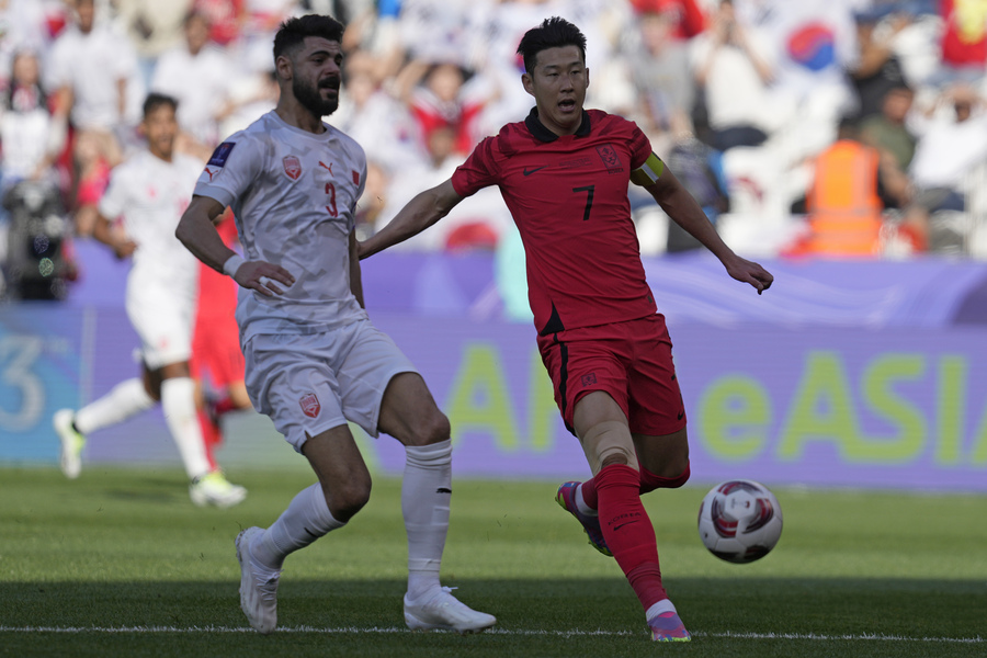 South Korea's Son Heung-min, right, is challenged by Bahrain's Waleed Alhayam during the Asian Cup Group E soccer match between South Korea and Bahrain at Jassim Bin Hamad Stadium in Doha, Qatar, Monday, Jan. 15, 2024. (AP)