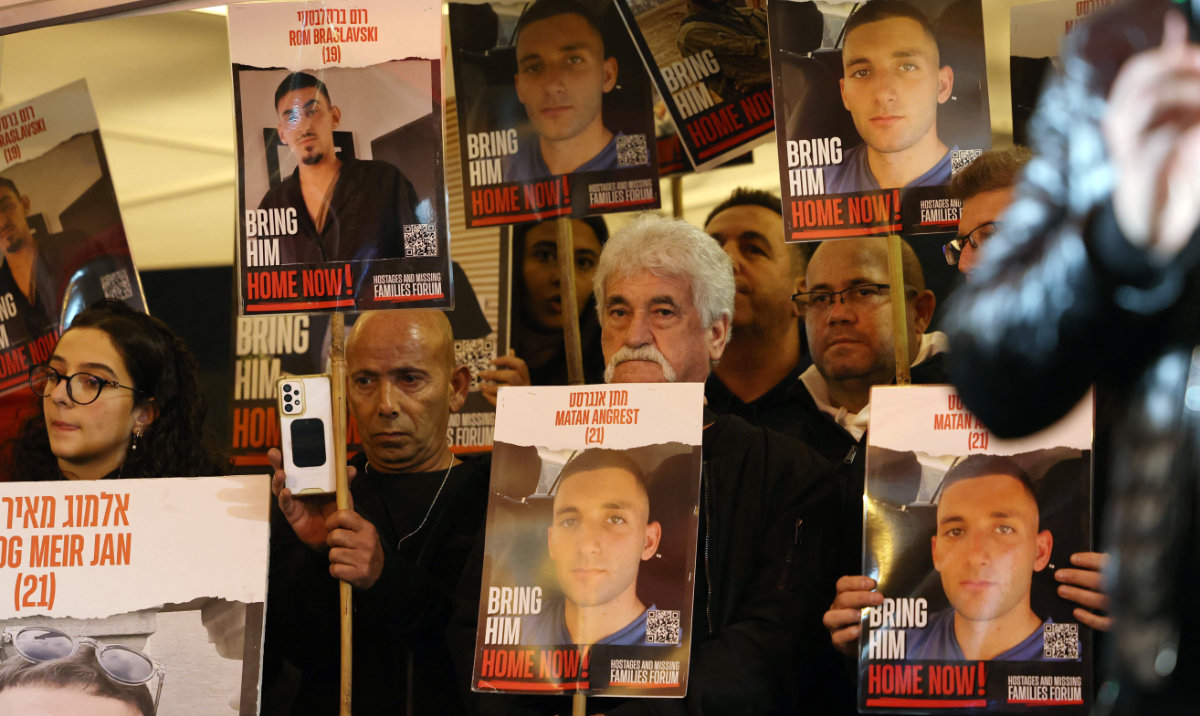 Relatives and supporters hold placards bearing portraits of Israeli hostages held in Gaza since the October 7 attacks by Hamas in southern Israel, during a rally calling for their release and marking their nearly 100 days of captivity, in Tel Aviv on January 13, 2024. (AFP)
