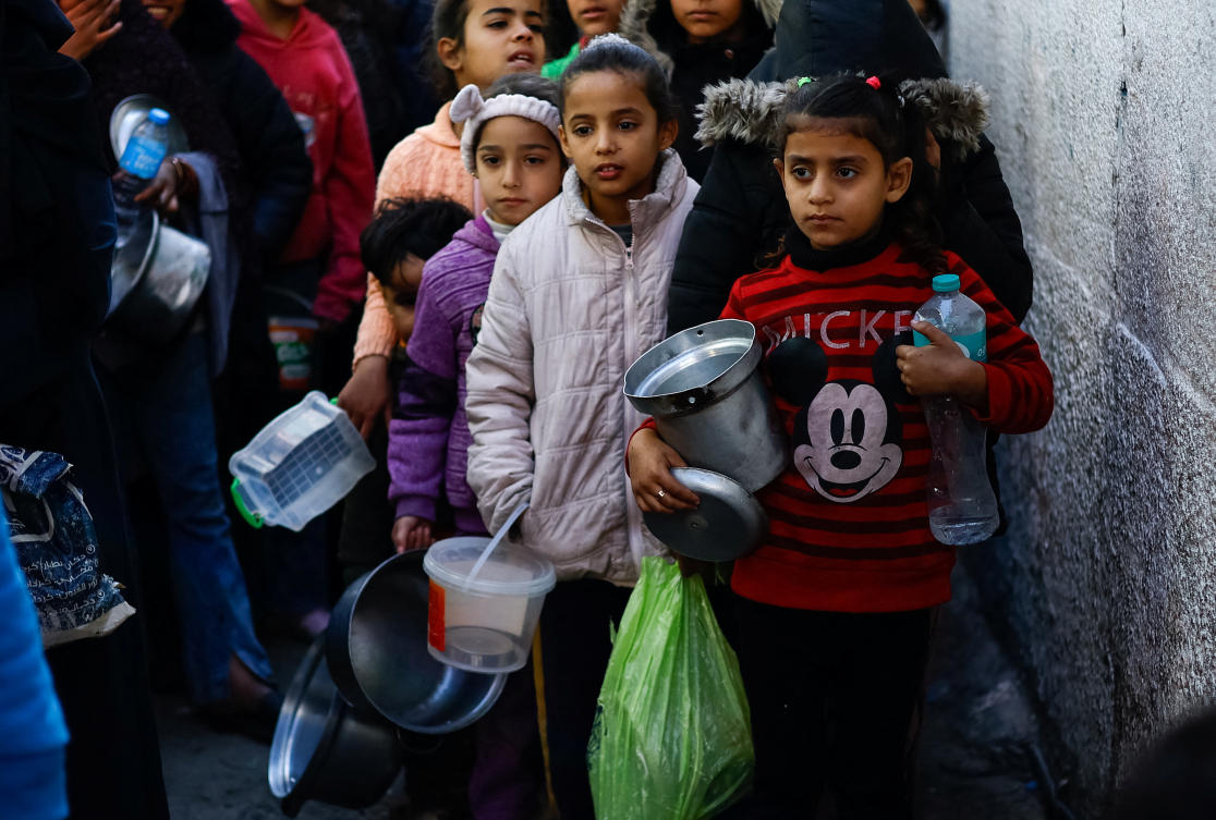 Palestinians wait to receive food cooked by a charity kitchen amid shortages of food supplies, amid the ongoing conflict between Israel and Hamas, in Rafah in the southern Gaza Strip, Jan. 16, 2024. (Reuters)