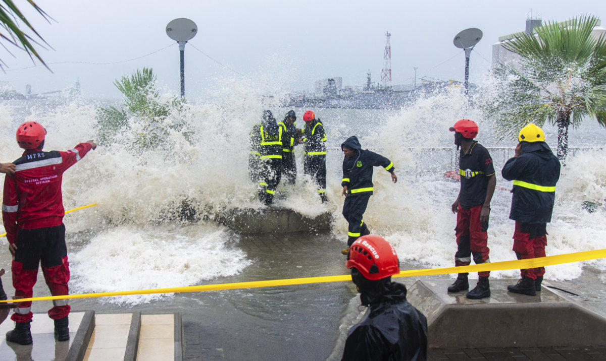 Workers are covered in water from a wave during a cyclone on the Caudan Waterfront in Port Louis, the capital city of Mauritius, Monday Jan. 15, 2024. (AP)