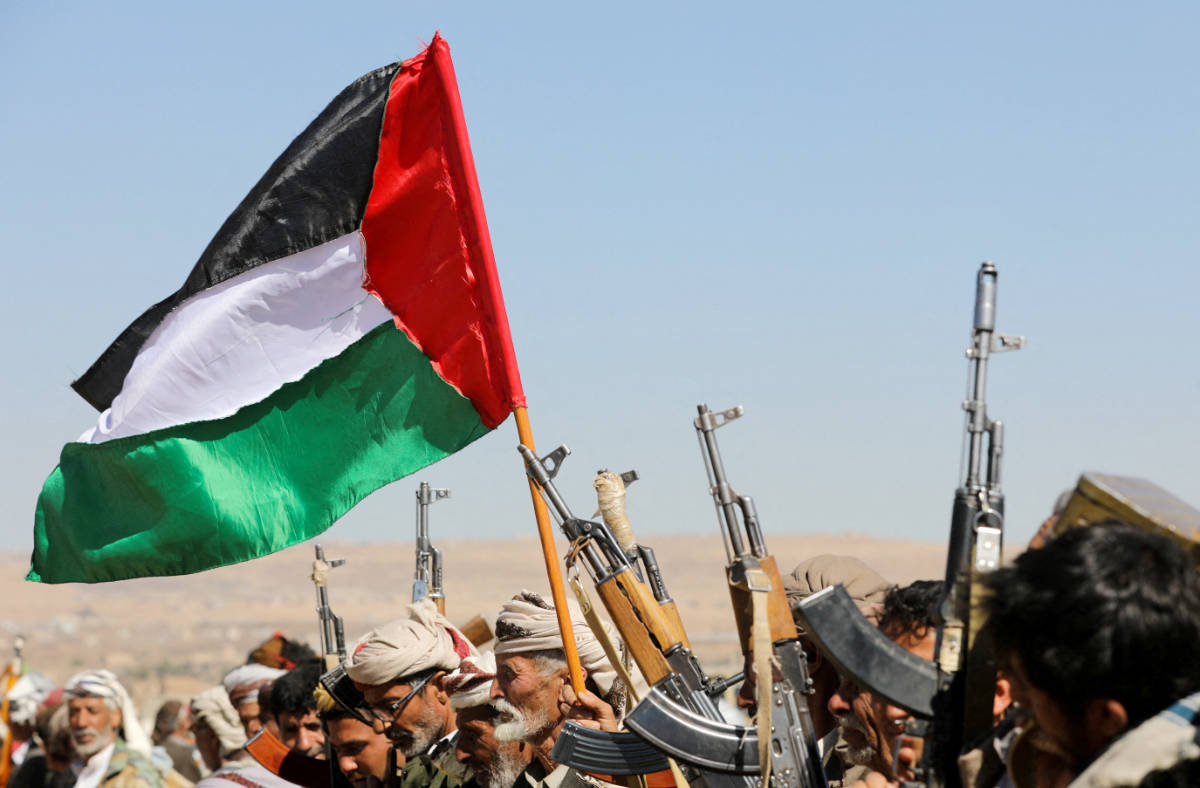 Tribal supporters of Yemen's Houthis wave a Palestinian flag and hold up their firearms during a protest on recent U.S.-led strikes on Houthi targets, near Sanaa, Yemen January 14, 2024. (REUTERS)