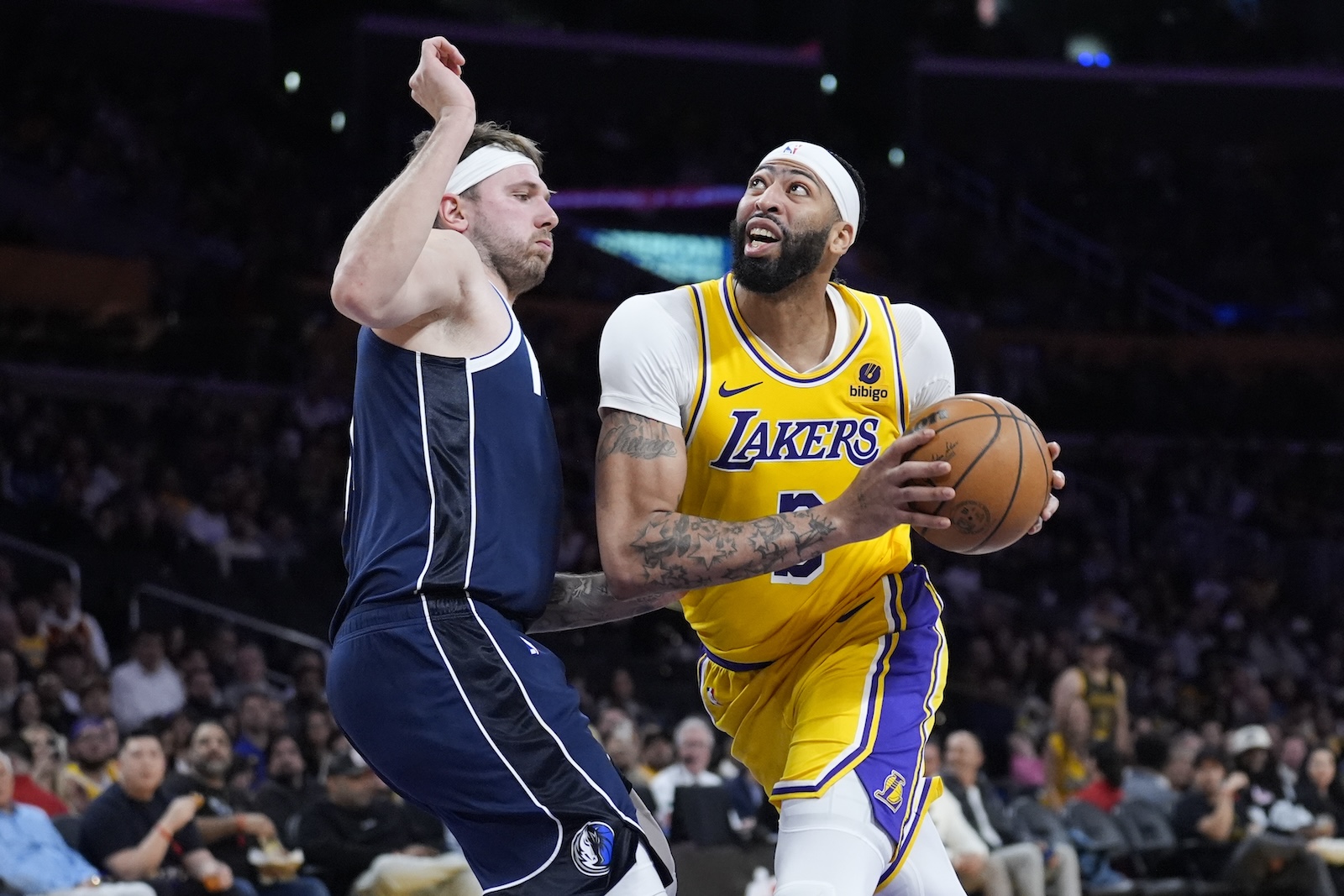 Los Angeles Lakers forward Anthony Davis, right, drives around Dallas Mavericks guard Luka Doncic during the second half of an NBA basketball game Wednesday in Los Angeles. (AP)
