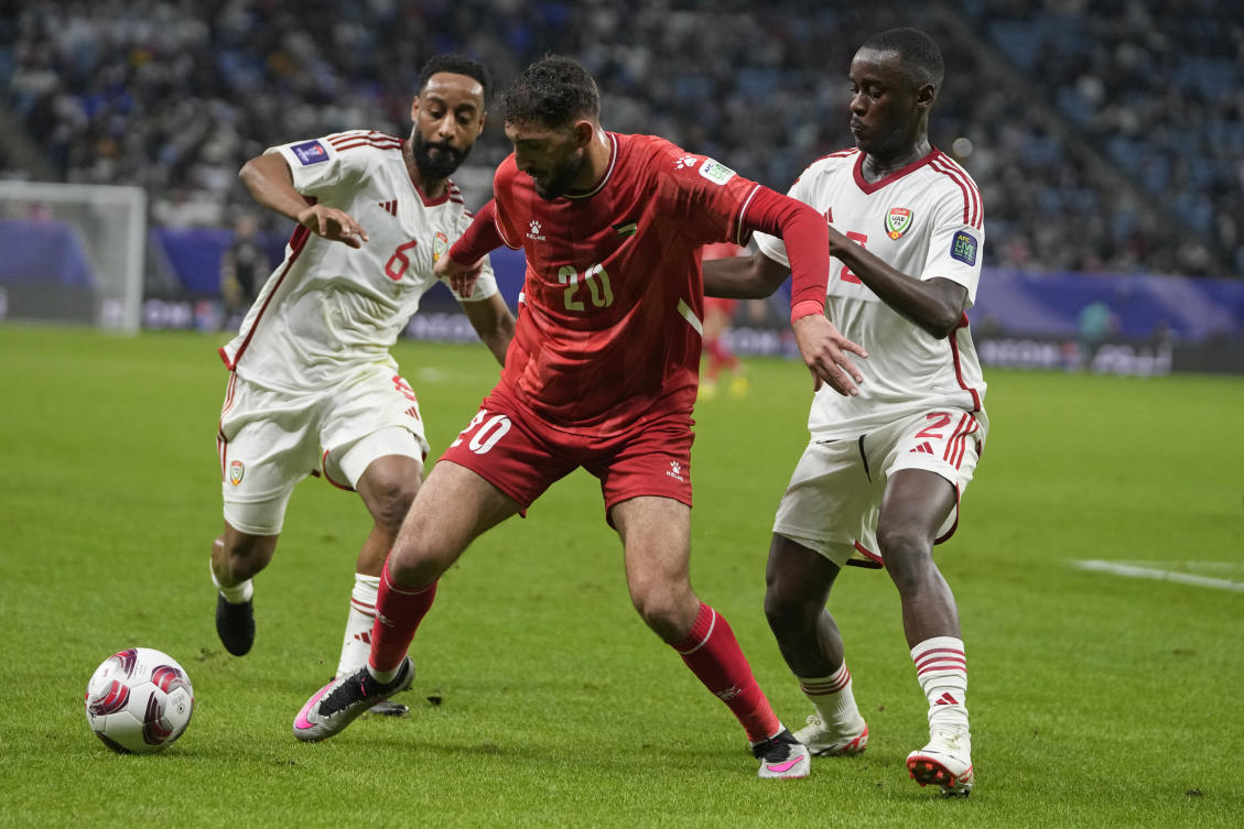 Palestine’s Zeid Qunbar, center, fights for the ball with United Arab Emirates’ Majid Rashid Almehrzi, left, and Abdulla Idrees Alhammadi during the Asian Cup Group C soccer match between Palestine and United Arab Emirates at Al Janoub Stadium in Al Wakrah, Qatar, Thursday, Jan. 18, 2024. (AP Photo/Thanassis Stavrakis)