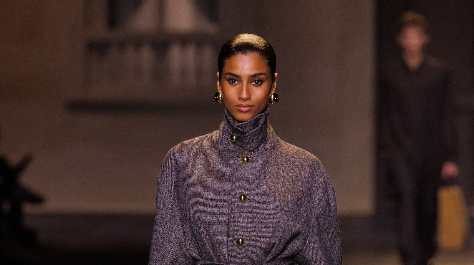 The 27-year-old model marched out of giant double doors in a long grey trench coat. (Getty Images)