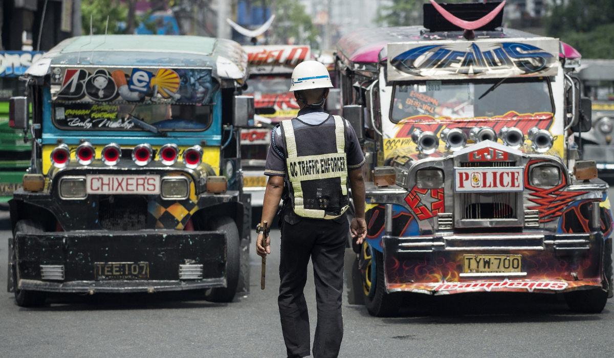 Jeepneys are seen as an enforcer manages traffic at a busy street in Manila, Philippines on May 30, 2017. (AFP)