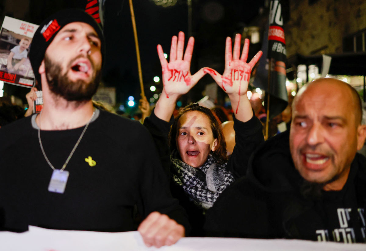 A demonstrator holds up their hands painted in red with the message "Time is running out" during a protest held by families of hostages and supporters to call for the immediate release of hostages kidnapped during the deadly October 7 attack by Palestinian Islamist group Hamas, outside Israeli Prime Minister Benjamin Netanyahu's residence, in Jerusalem January 22, 2024. (REUTERS)