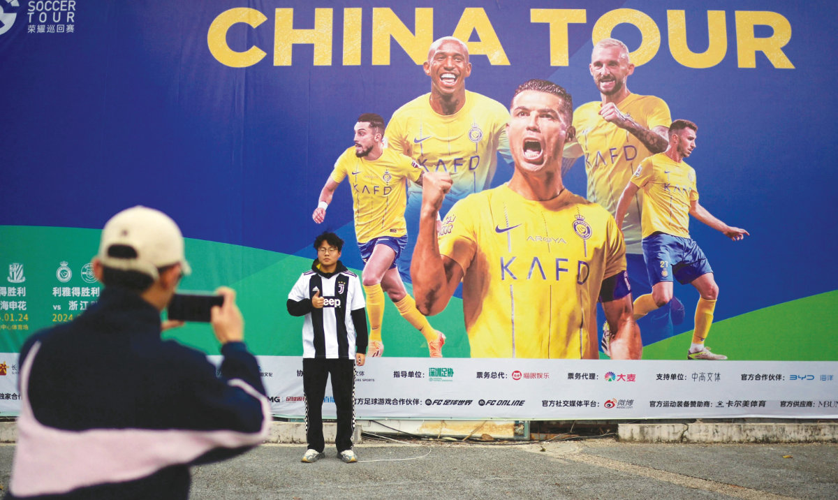 A fan of Cristiano Ronaldo of Al-Nassr poses for a picture prior to a training session ahead of the postponed friendly match against Shanghai Shenhua during China Tour at the Universiade Sports Center in Shenzhen, Guangdong Province, on Tuesday. (AFP)