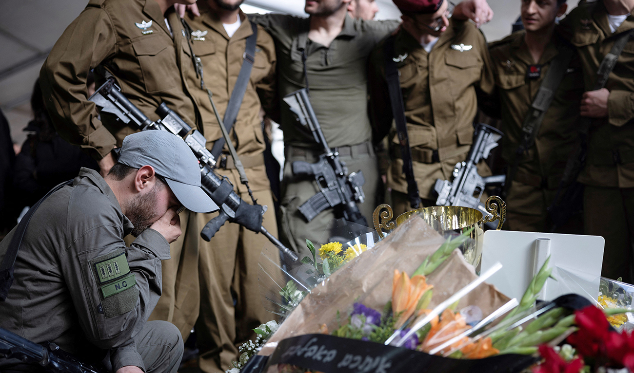 Fellow soldiers mourn during the funeral of an Israeli soldier at the military cemetery in Tel Aviv, on January 23, 2024. (AFP)
