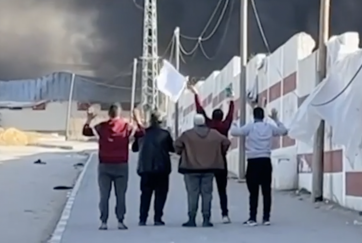 A group of five Palestinian men waving a white flag moments before one was shot dead by an Israeli soldier. (Screenshot)
