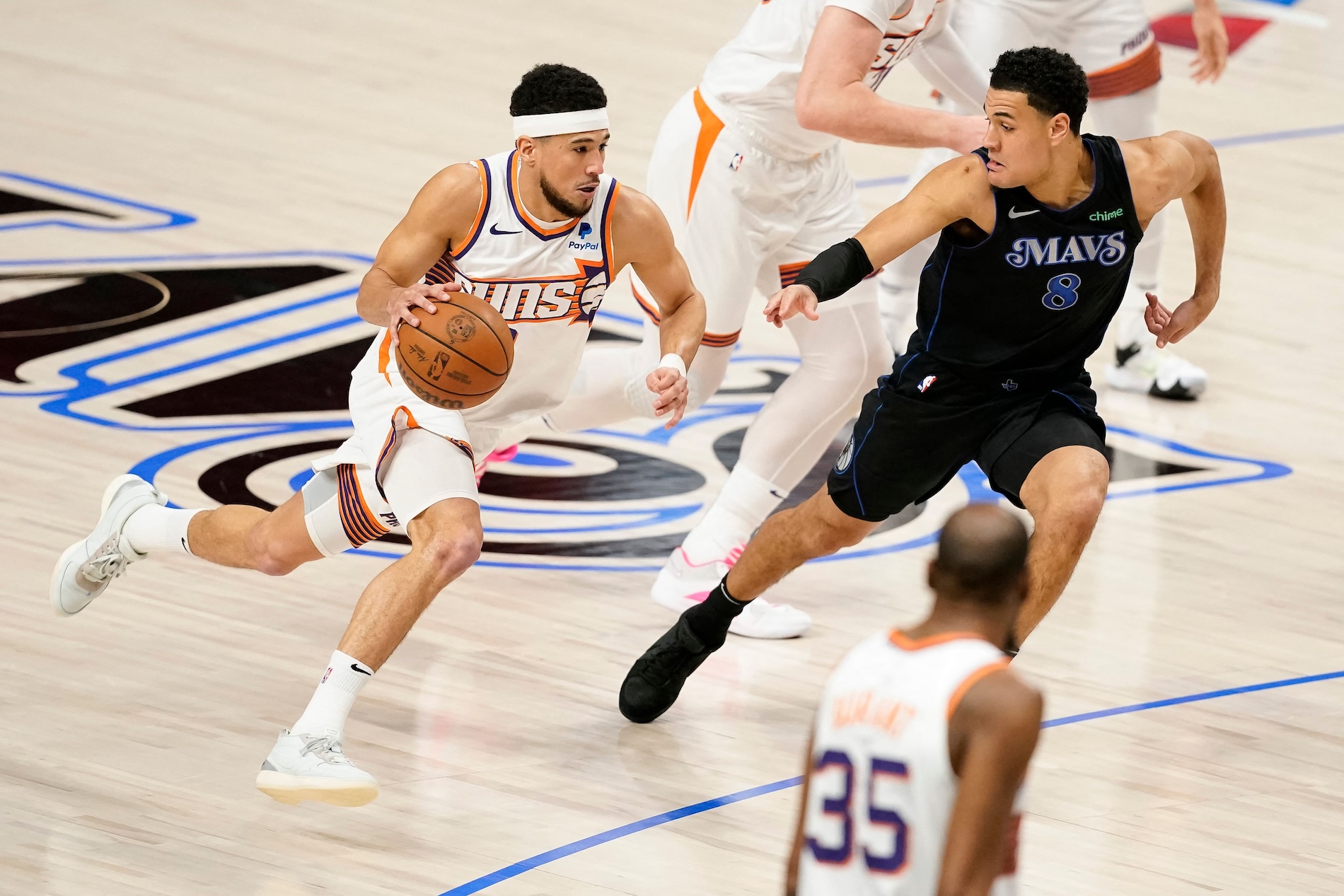 Devin Booker of the Phoenix Suns drives with the ball as Josh Green of the Dallas Mavericks defends during the first half of an NBA game at American Airlines Center on Jan. 24, 2024 in Dallas, Texas. (AFP)