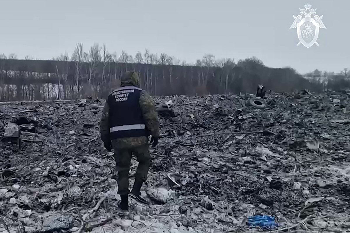 In this grab taken from a handout footage released by the Russian Investigative Committee on January 25, 2024, an investigator works at the military transport plane crash site in the Belgorod region of Russia. (AFP)