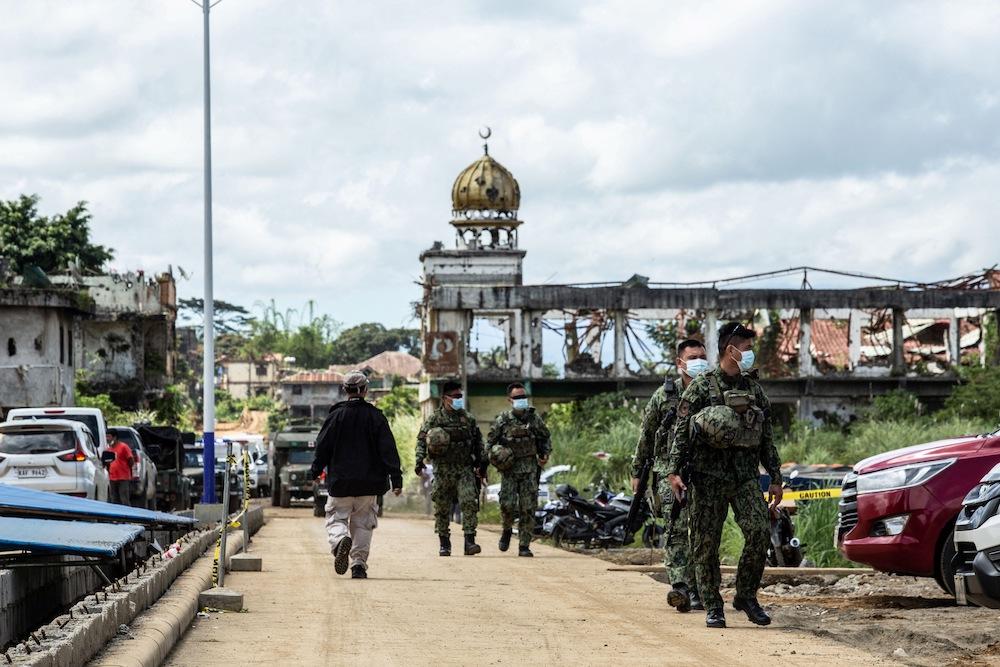 Militant attacks on buses, Catholic churches and public markets have been a feature of decades-long unrest in the south. Above, Philippine soldiers walk past ruins of a mosque which was destroyed in 2017 when Daesh-inspired Muslim militants laid siege to the southern city of Marawi. (AFP)