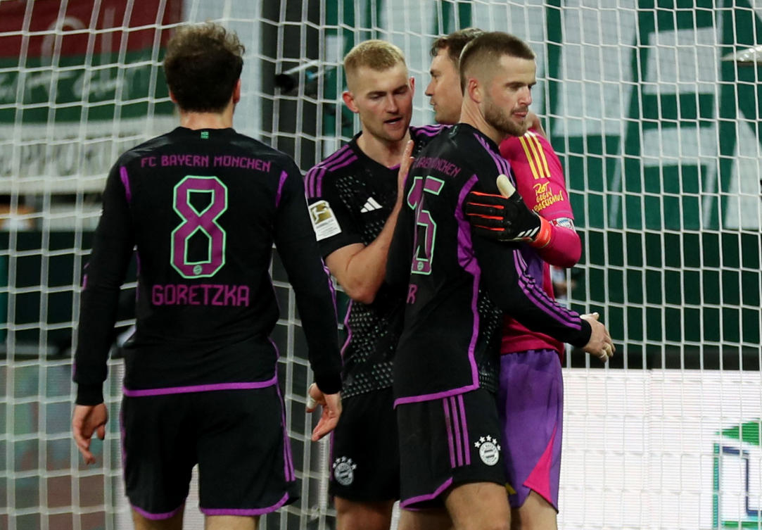 Bayern Munich’s Manuel Neuer is congratulated by Eric Dier and Matthijs de Ligt after saving a penalty from FC Augsburg’s Sven Michel during their Bundesliga match at WWK Arena, Augsburg, on Jan. 27, 2024. (Reuters)