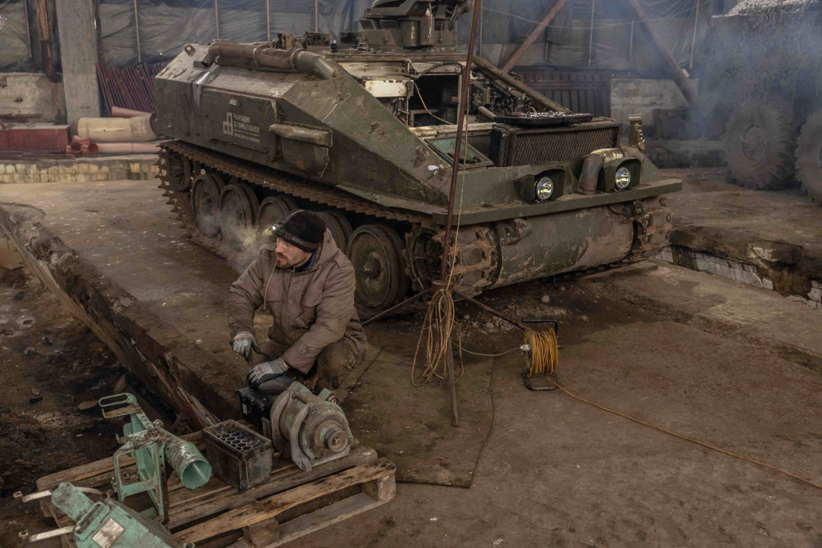 A Ukrainian mechanic of the 24th Brigade repairs a British FV103 Spartan armored personnel carrier at a workshop, in the Donetsk region, on January 25, 2024, amid the Russian invasion of Ukraine. (AFP)