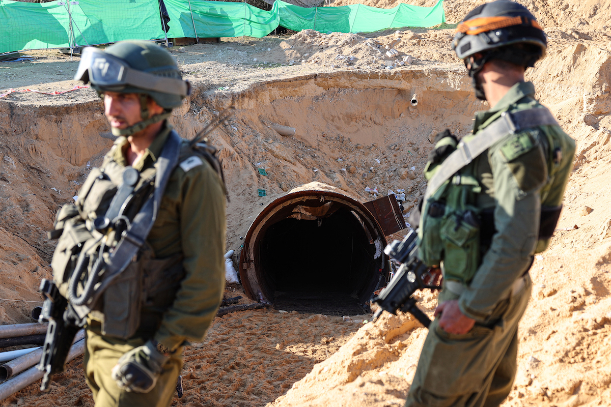 Soldiers stand at the entrance of a tunnel that Hamas reportedly used to attack Israel through the Erez border crossing on October 7. (File/AFP)