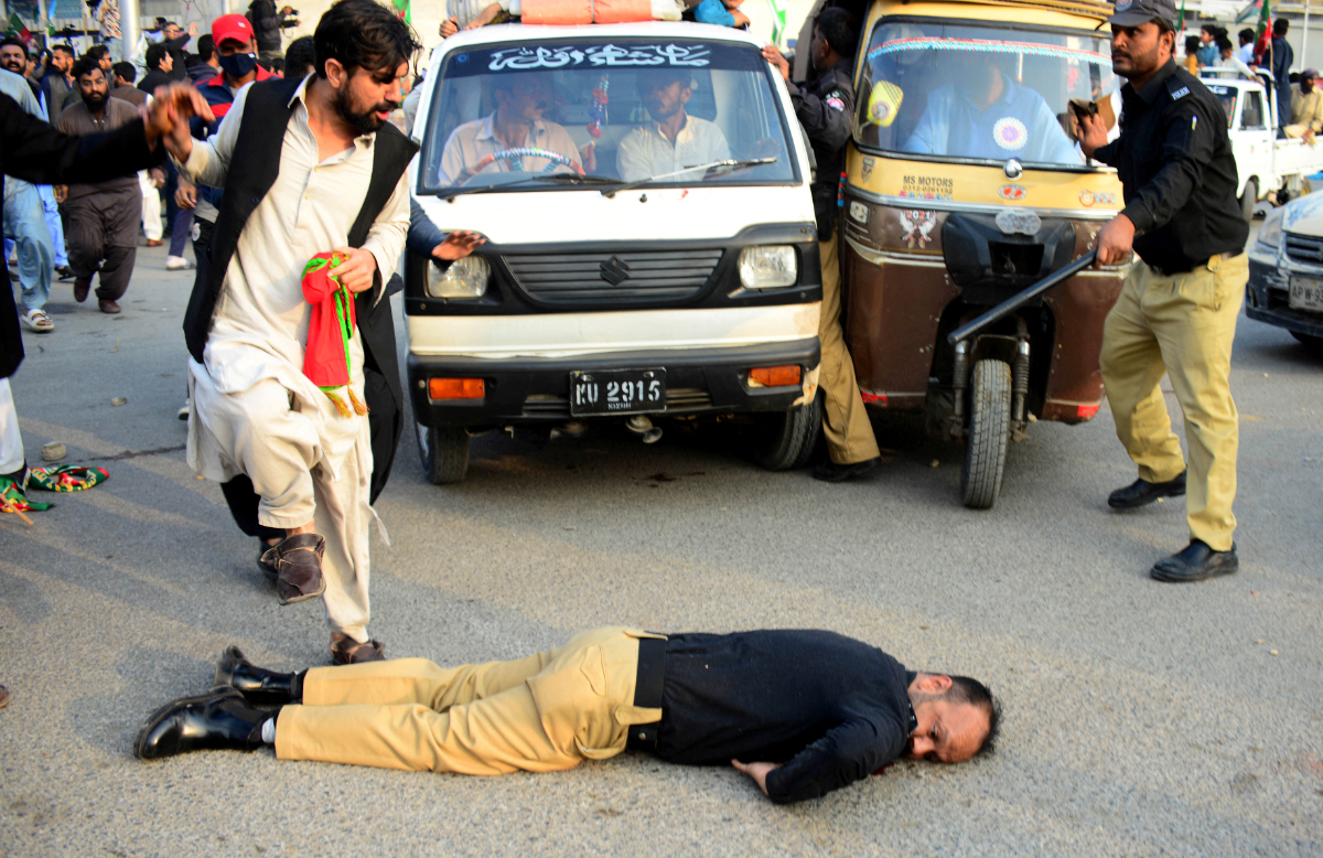 An injured police officer lies on the road during a clash with supporters of former prime minister Imran Khan's party, the Pakistan Tehreek-e-Insaf (PTI), at a rally ahead of a general election, in Karachi, Pakistan, January 28, 2024. (REUTERS)