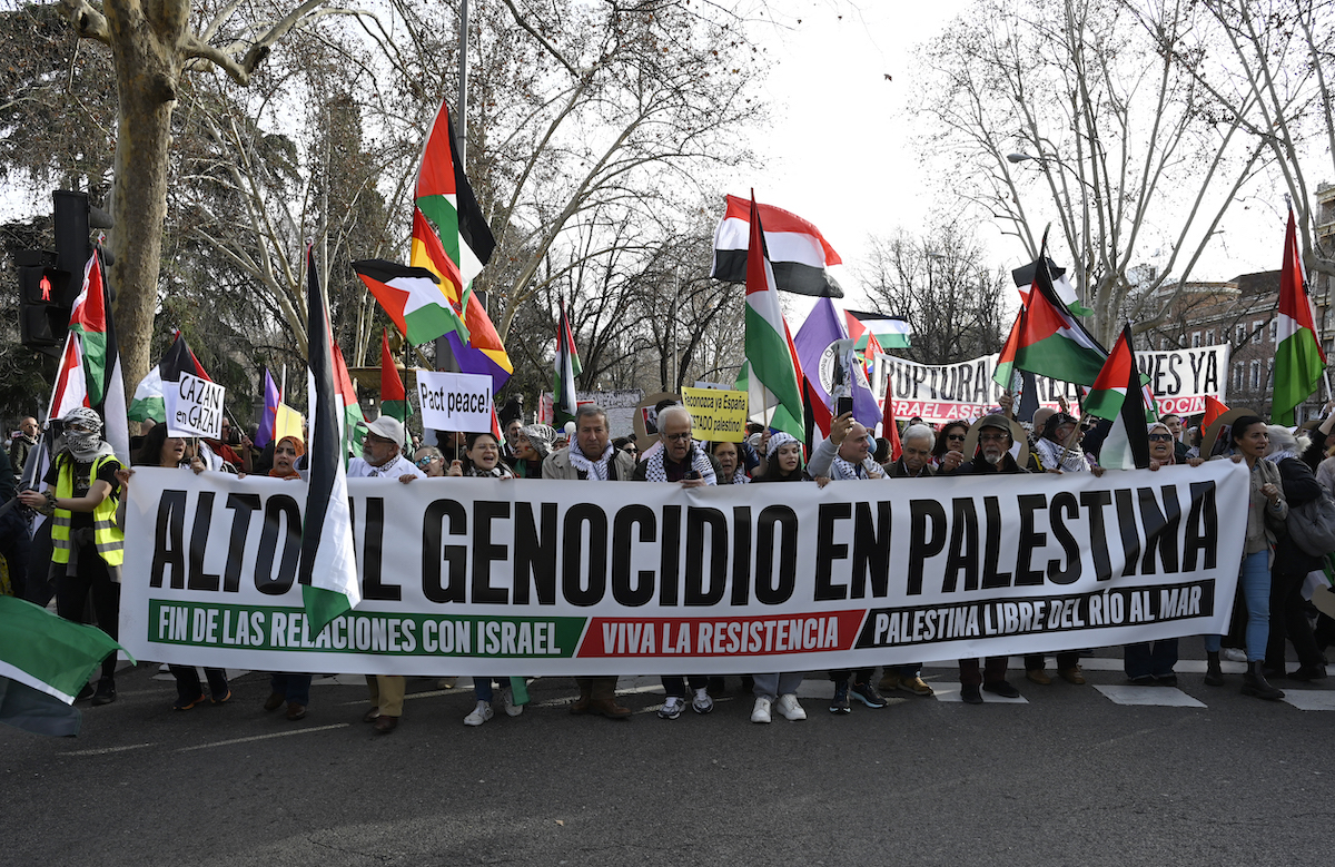 Protesters hold a banner reading "Stop the genocide in Palestina" as they demonstrate in support of the people from Gaza, in the Palestinian territories, in Madrid. (File/AFP)