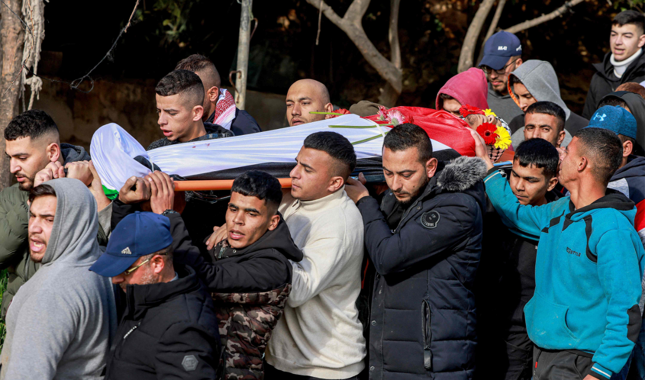 Mourners carry the body of a Palestinian teenager during his funeral on Monday in the West Bank. (AFP)