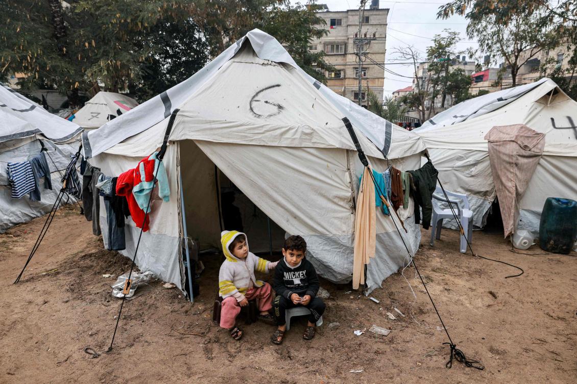Children sit at the entrance of a tent at a make-shift camp for displaced Palestinians in Rafah in the southern Gaza Strip on January 29, 2024, amid the ongoing conflict between Israel and Hamas. (AFP)