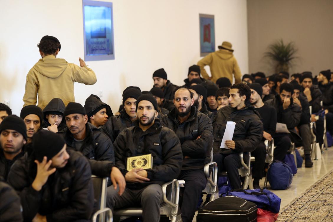 Illegal migrants from Egypt sit in a waiting room during a deportation operation in the Libyan capital Tripoli on Jan. 31, 2024. (AFP)