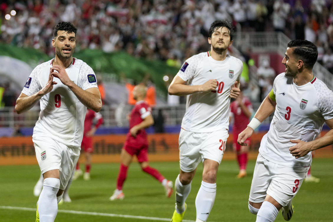 Iran’s Mehdi Taremi, left, celebrates after scoring his side’s opening goal from a penalty spot during their Asian Cup Round of 16 match against Syria, at Abdullah Bin Khalifa Stadium in Doha on Jan. 31, 2024. (AP)