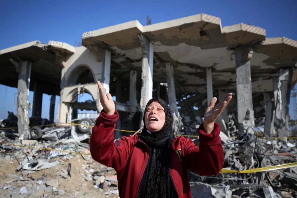A Palestinian woman stands in front of a destroyed building in Al-Maghazi refugee camp, central Gaza Strip, Jan. 16, 2024, amid ongoing battles between Israel and the Palestinian group Hamas. (AFP)