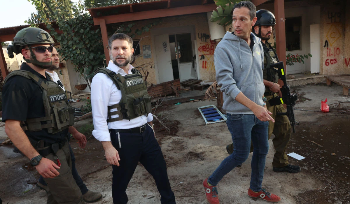 Far-right Israeli Finance Minister Bezalel Smotrich walks with soldiers during a visit to Kibbutz Kfar Aza near the border with the Gaza Strip on November 14, 2023, in the aftermath of an attack by Palestinian militants on October 7. (AFP)
